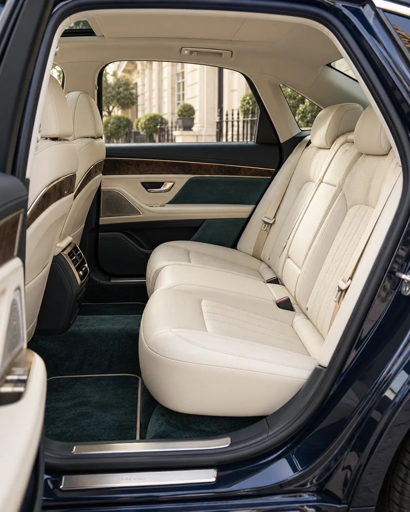 Cream leather rear passenger seating with dark wood and teal trim